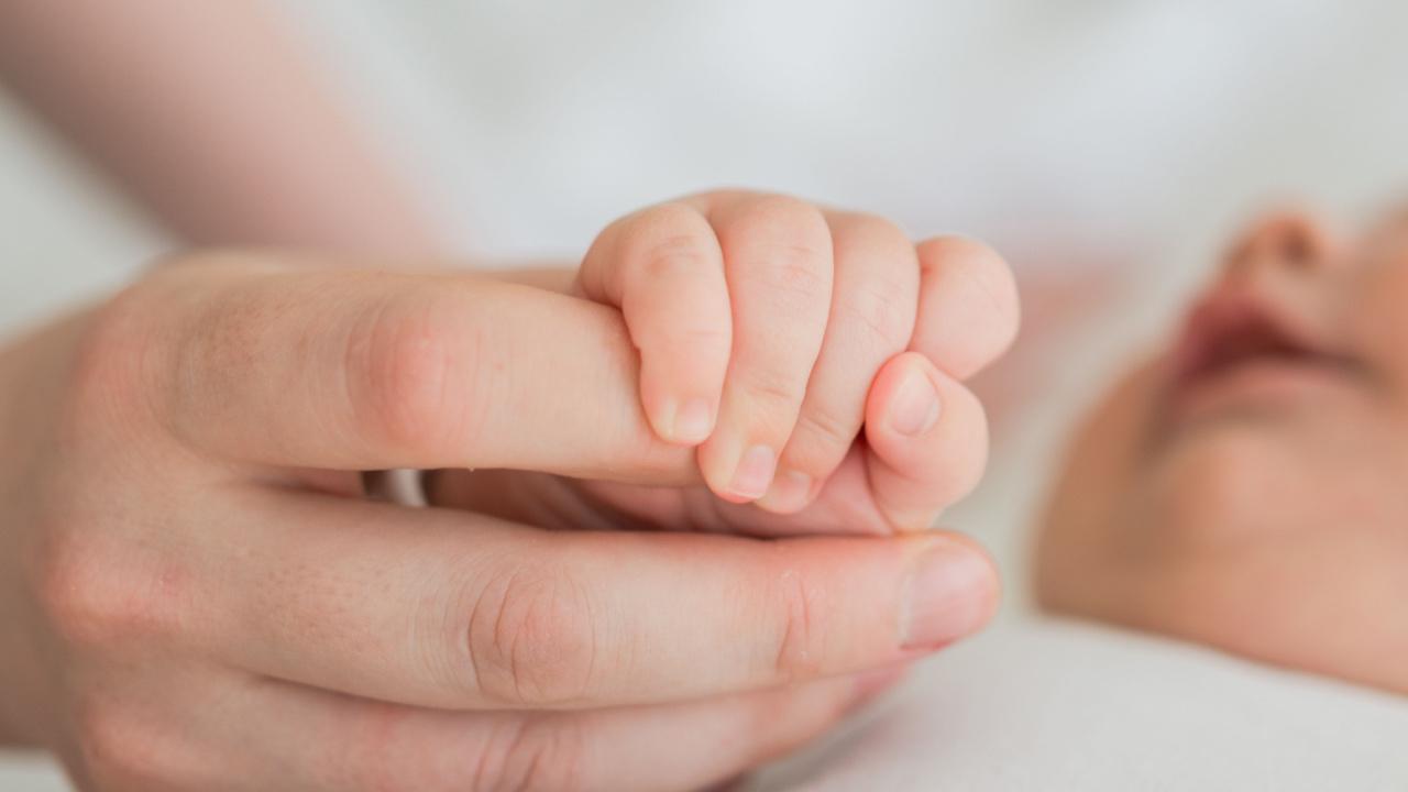 Naujagimis spaudžia mamos pirštą