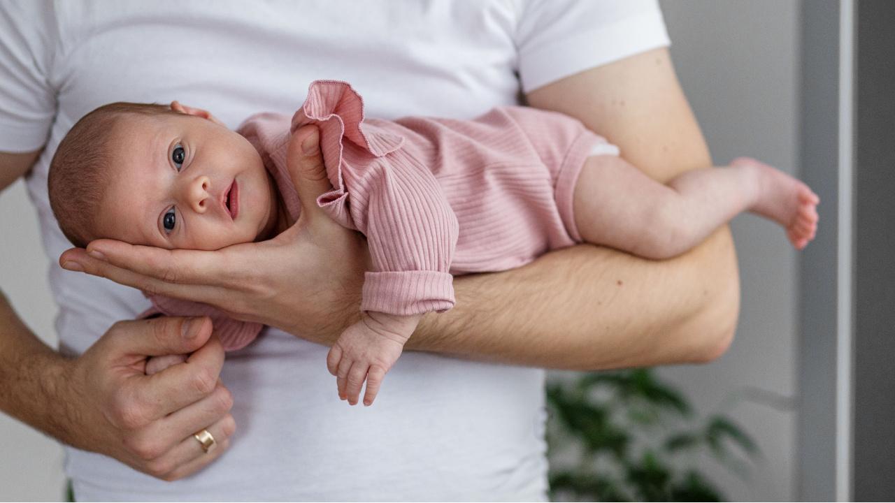 Tėtis nešioja dieglių kamuojamą kūdikį tigriuko pozoje