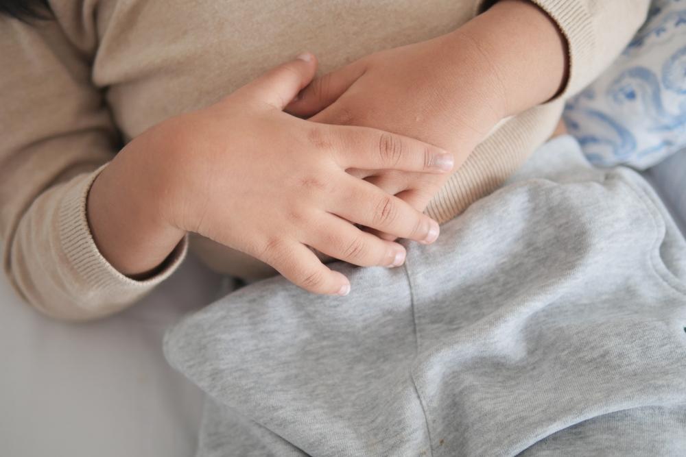 Vaikas susiėmęs už pilvuko